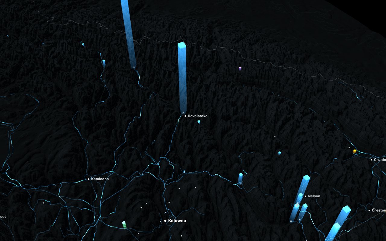 British Columbia in relief at night, generating stations as columns of light and the high-voltage grid glowing across the province